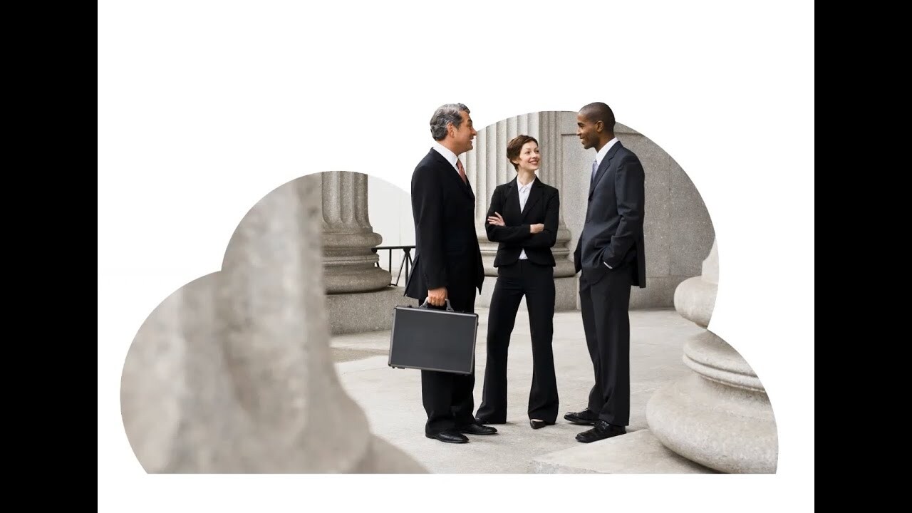 Three executives in black suits standing and chatting in a hall, circled by huge pillars.