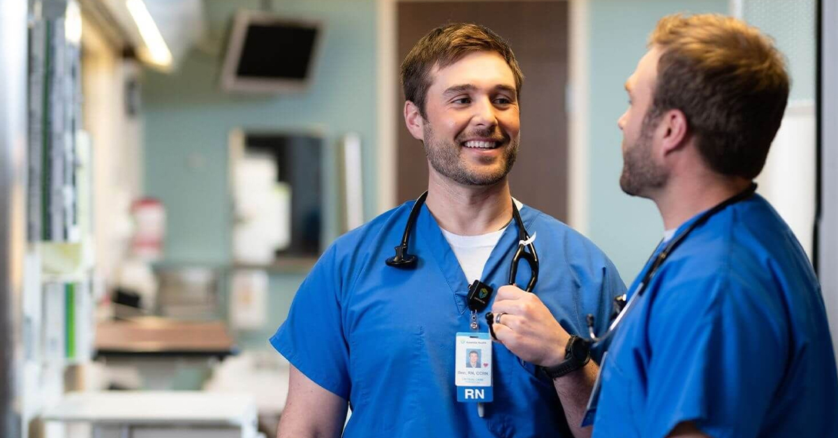 Two Essentia Health nurses in blue scrubs talking in a hospital corridor, from the Workday Paradox customer story