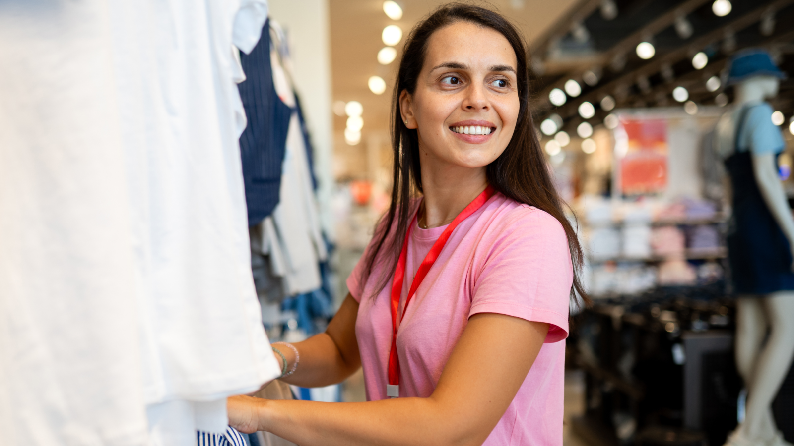 Image of a female worker smiling and sorting through clothes.