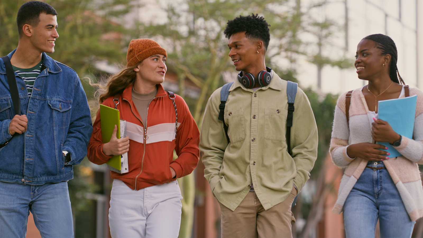Four college aged people walking and talking
